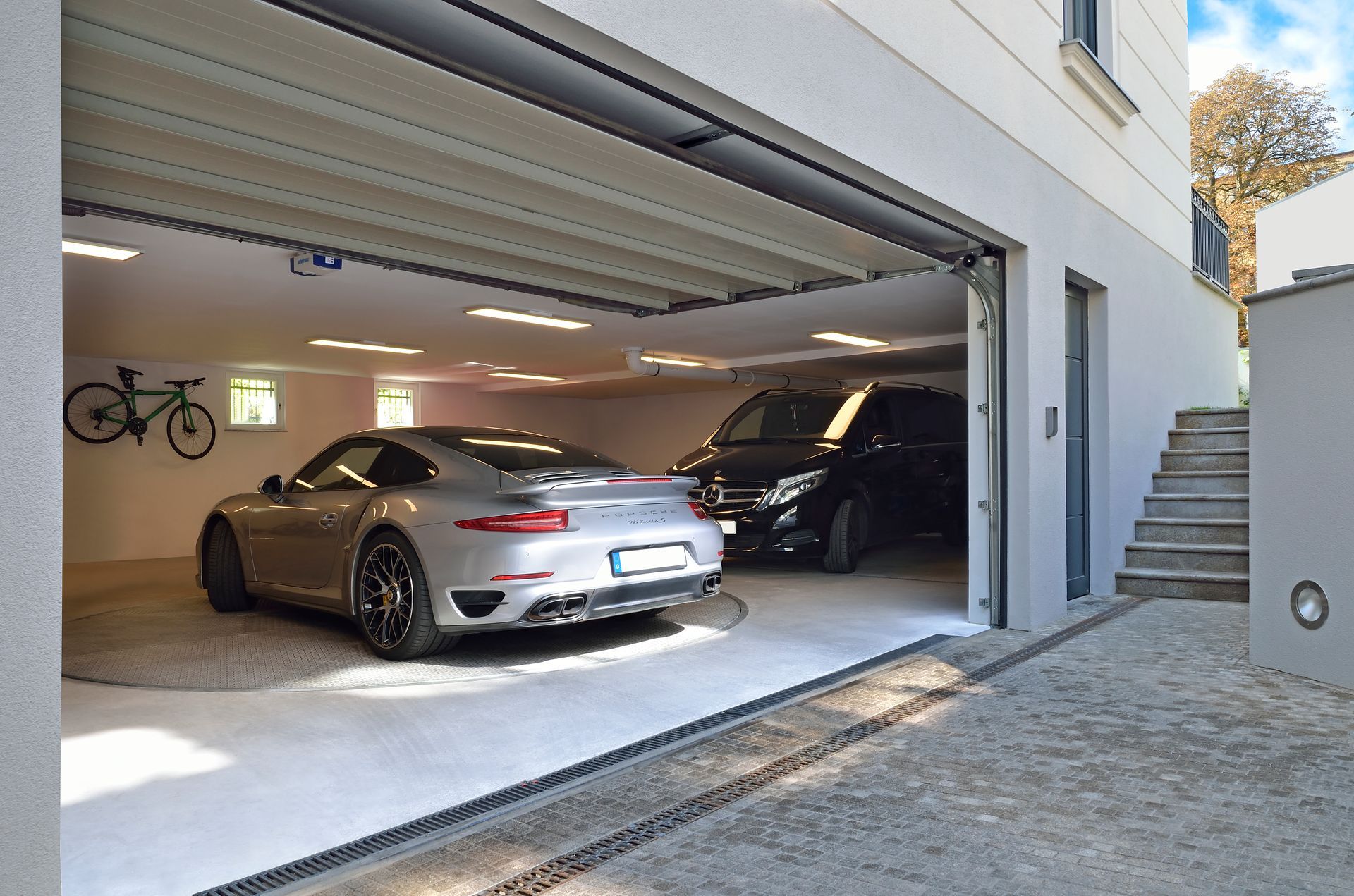 En bil er parkeret i en garage med åben dør.