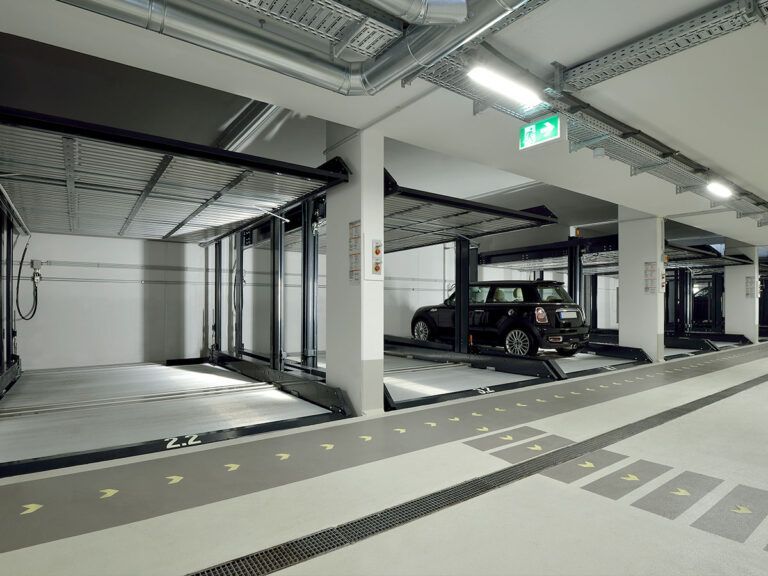 En sort bil er parkeret i en parkeringskælder.