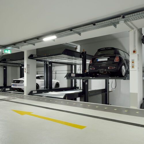 En bil er parkeret på en elevator i en parkeringskælder