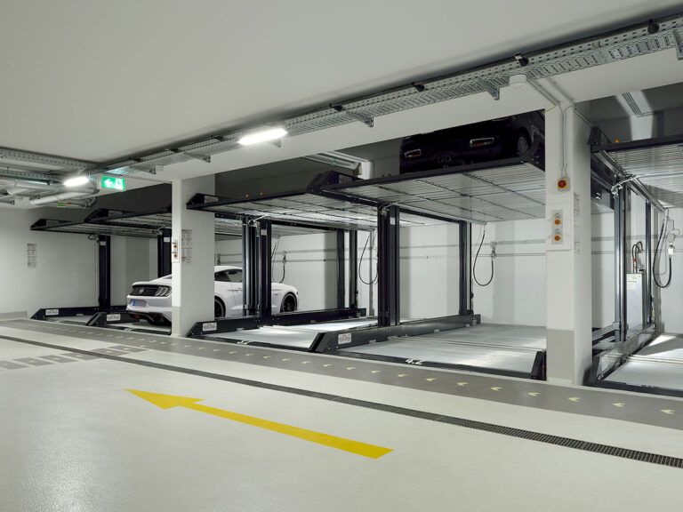 En hvid bil er parkeret i en parkeringskælder