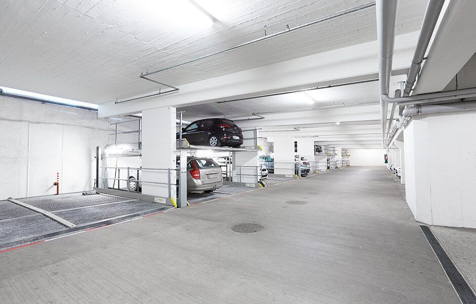 En parkeringskælder med biler parkeret oven på hinanden.