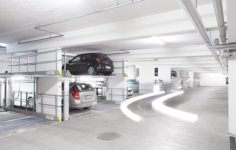 To biler er parkeret oven på hinanden i en parkeringskælder.