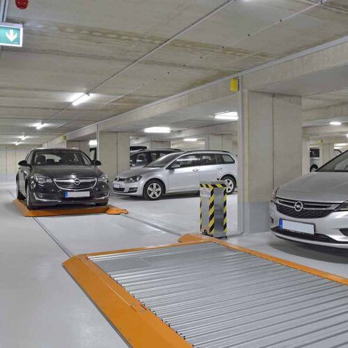 En række biler er parkeret i en parkeringskælder.