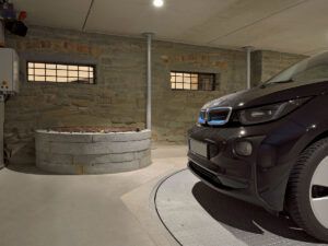 En sort bil er parkeret på en drejeskive i en garage.