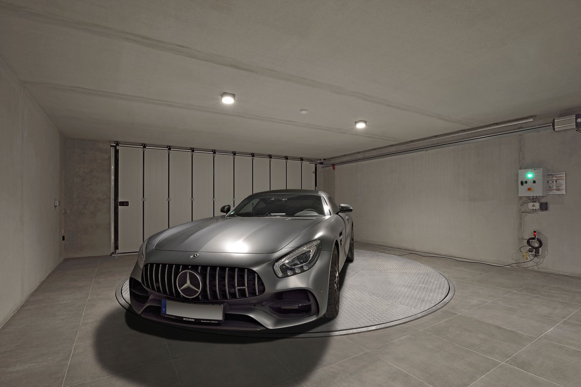 En mercedes amg gt er parkeret i en garage på en drejeskive.