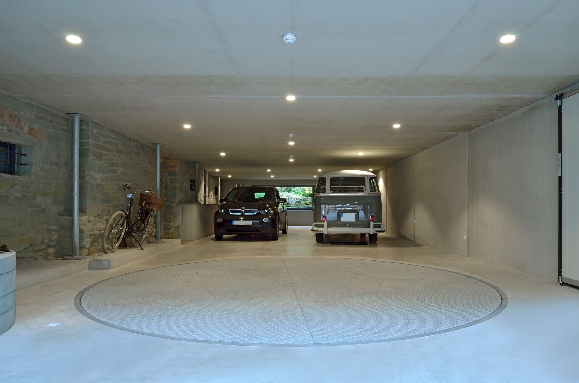 To biler er parkeret i en garage med en drejeskive.