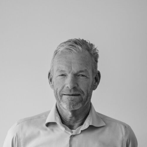 Et sort/hvidt foto af en mand med skæg iført skjorte.