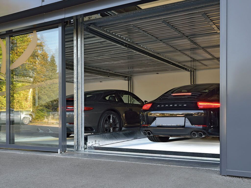 To biler er parkeret i en garage med åben dør