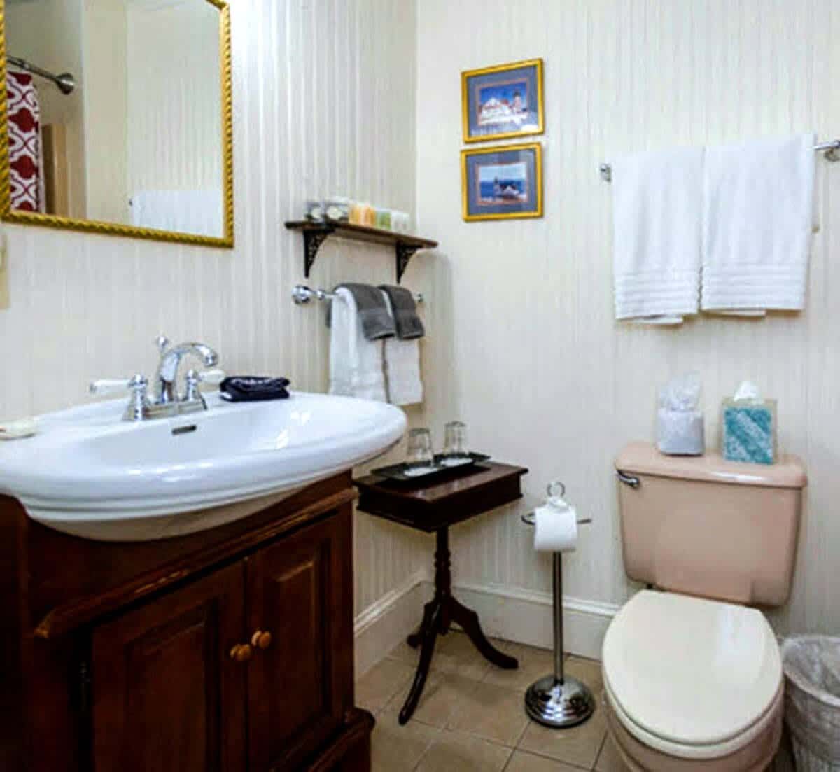 A bathroom with a sink toilet and mirror