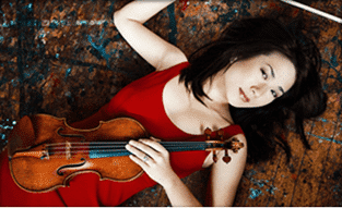 A woman in a red dress is laying on the floor holding a violin.