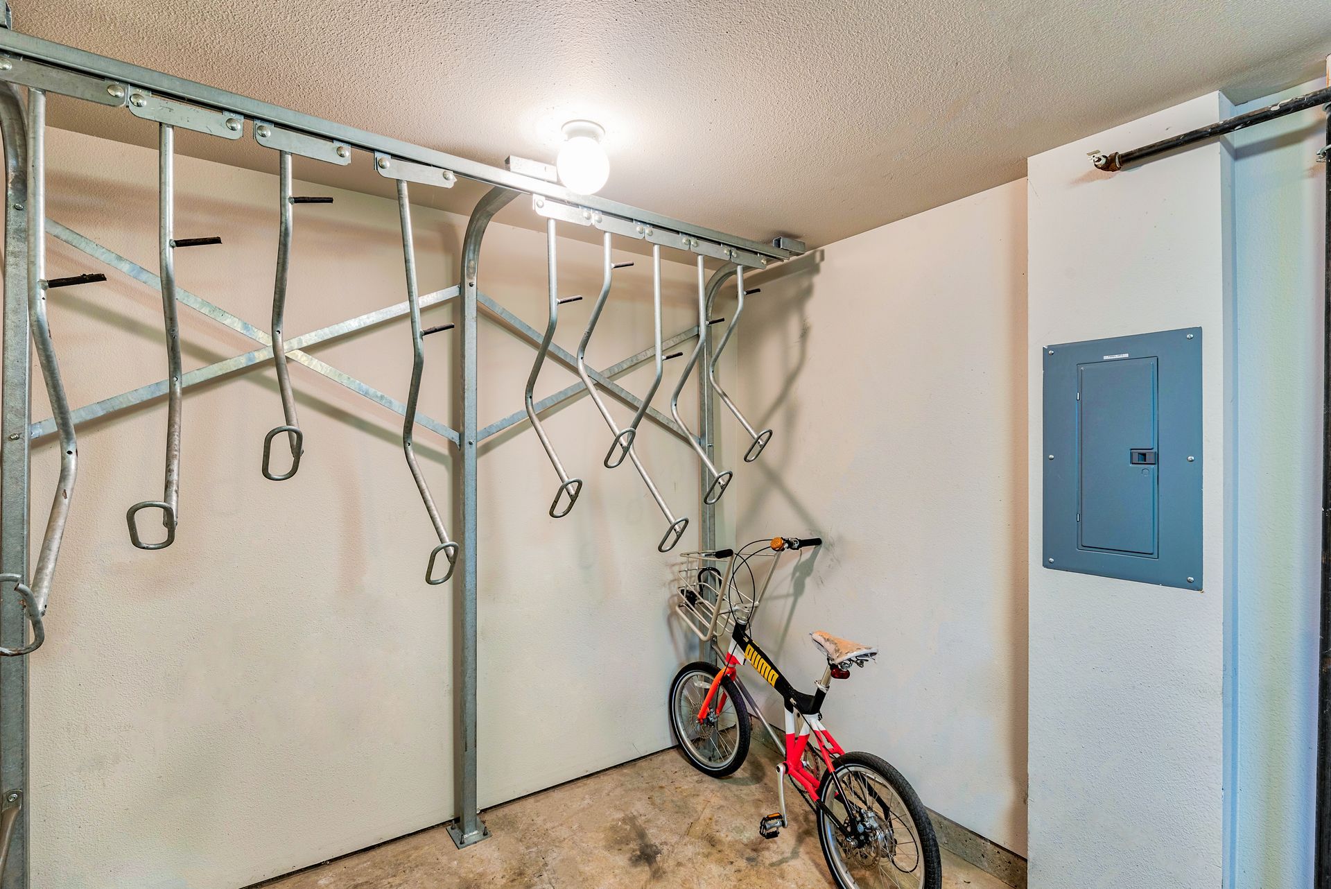 Indoor garage with wall-mounted metal bike storage and a red bicycle on the floor.