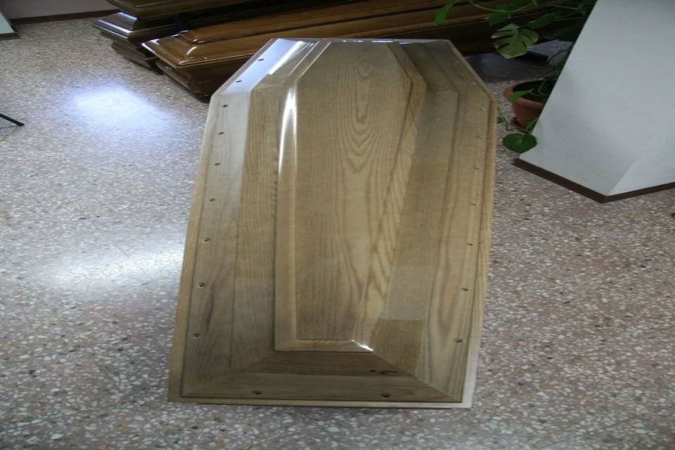 Una bara di legno è appoggiata su un pavimento piastrellato