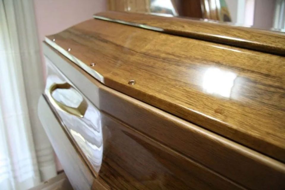Un primo piano di una bara di legno in una stanza