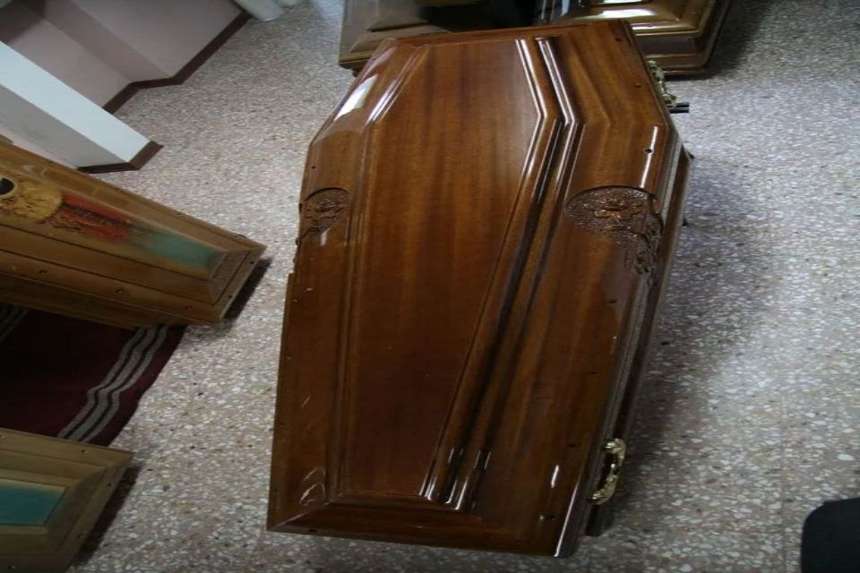 Una bara di legno è appoggiata sul pavimento in una stanza