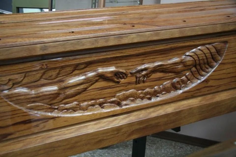 Una bara di legno con un'incisione di mani su di essa