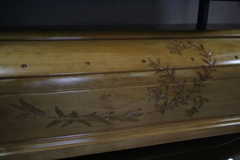 Una bara di legno con una corona intagliata al suo interno.