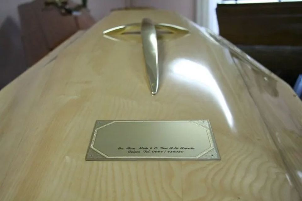 Una bara di legno con una croce d'oro sopra