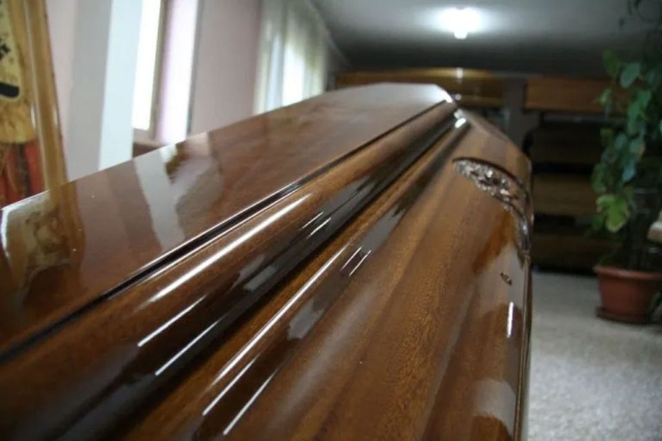Un primo piano di una bara di legno in una stanza