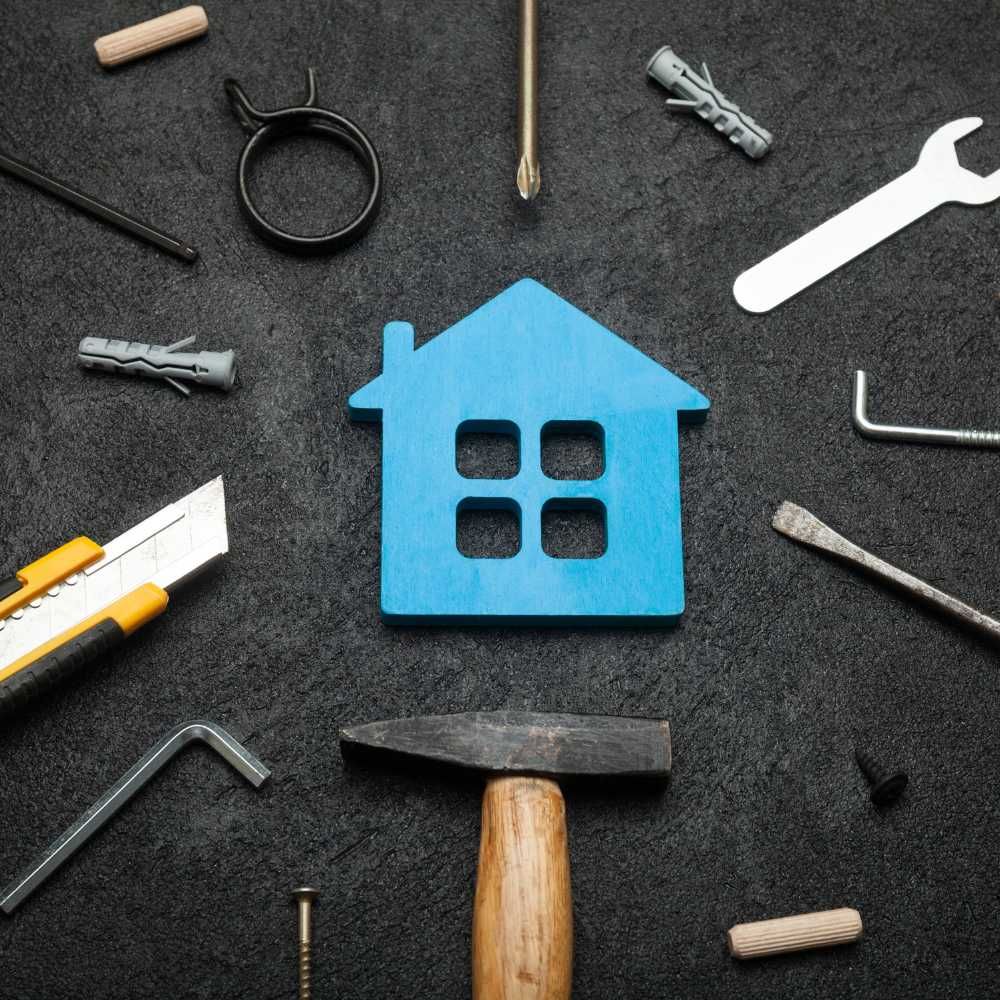 A blue house is surrounded by tools on a black surface.