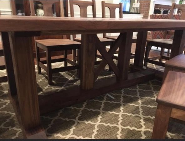 A wooden table and chairs in a room with a rug