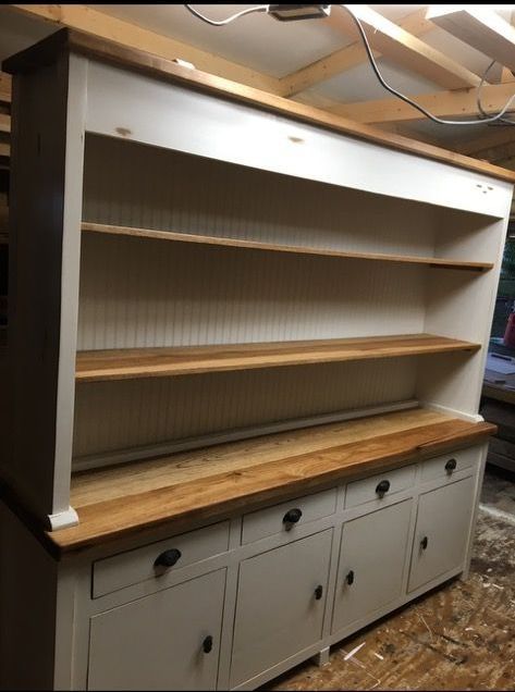 A white cabinet with wooden shelves and drawers