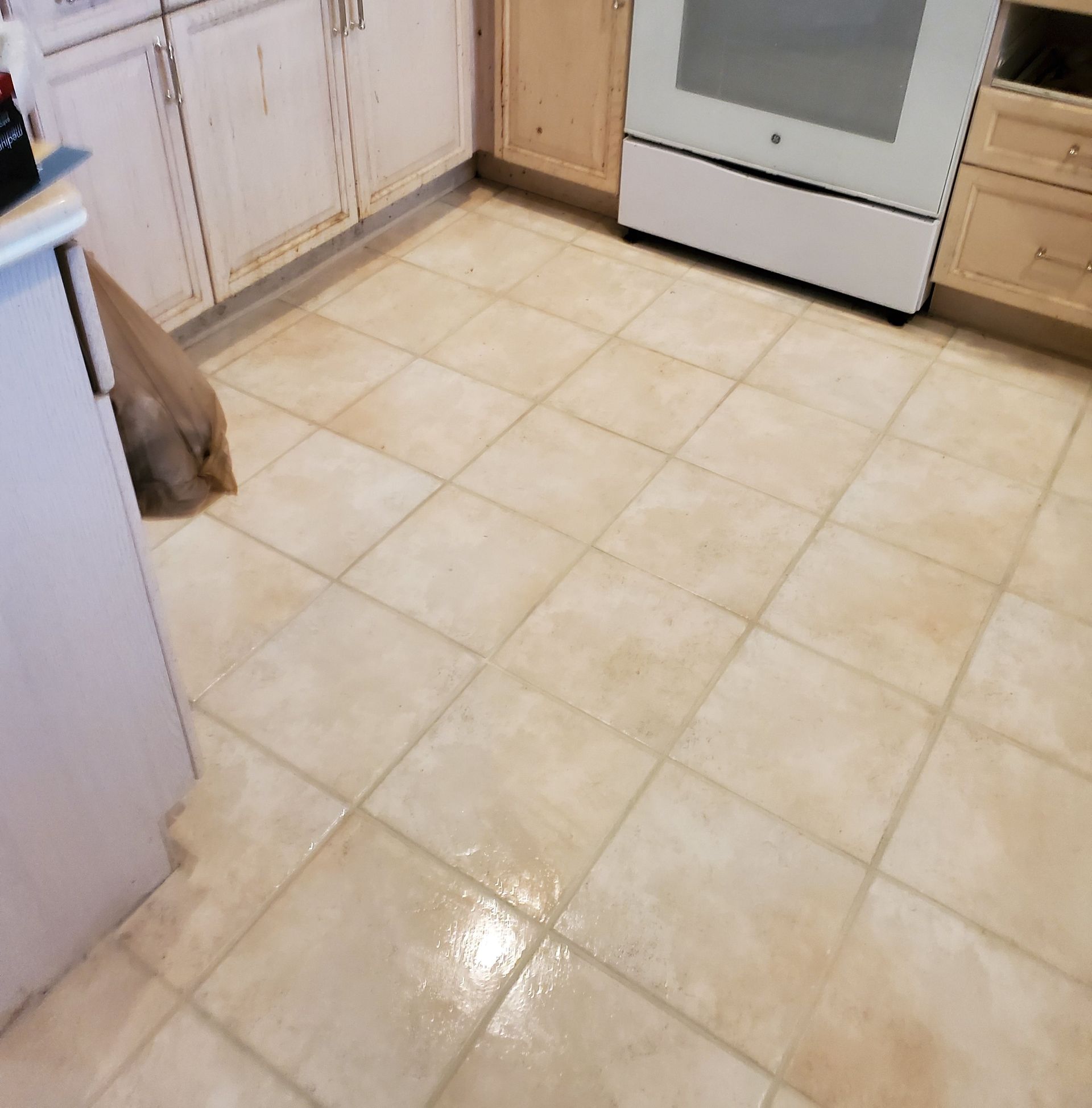 A kitchen with tile floors and a white stove