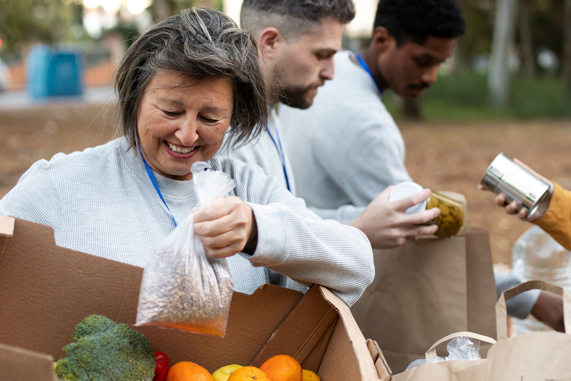 Volunteers packing produce and canned goods into boxes at a food drive