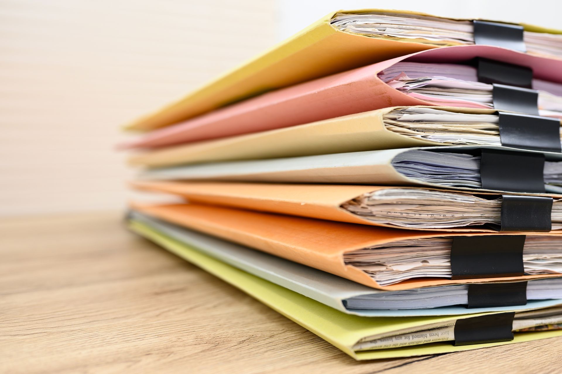 Stack of colorful folders on a wooden desk