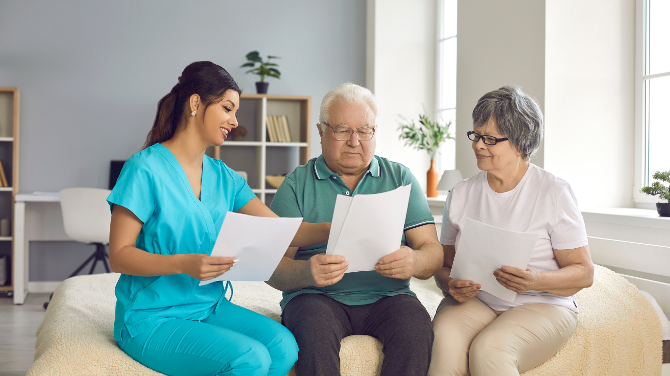 An elderly man sitting with a nurse taking his blood pressure