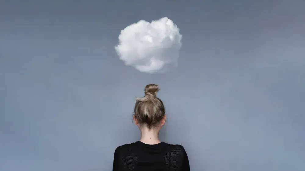 A Woman Is Looking at A Cloud Above Her Head — Health Hub Mackay in Mackay, QLD