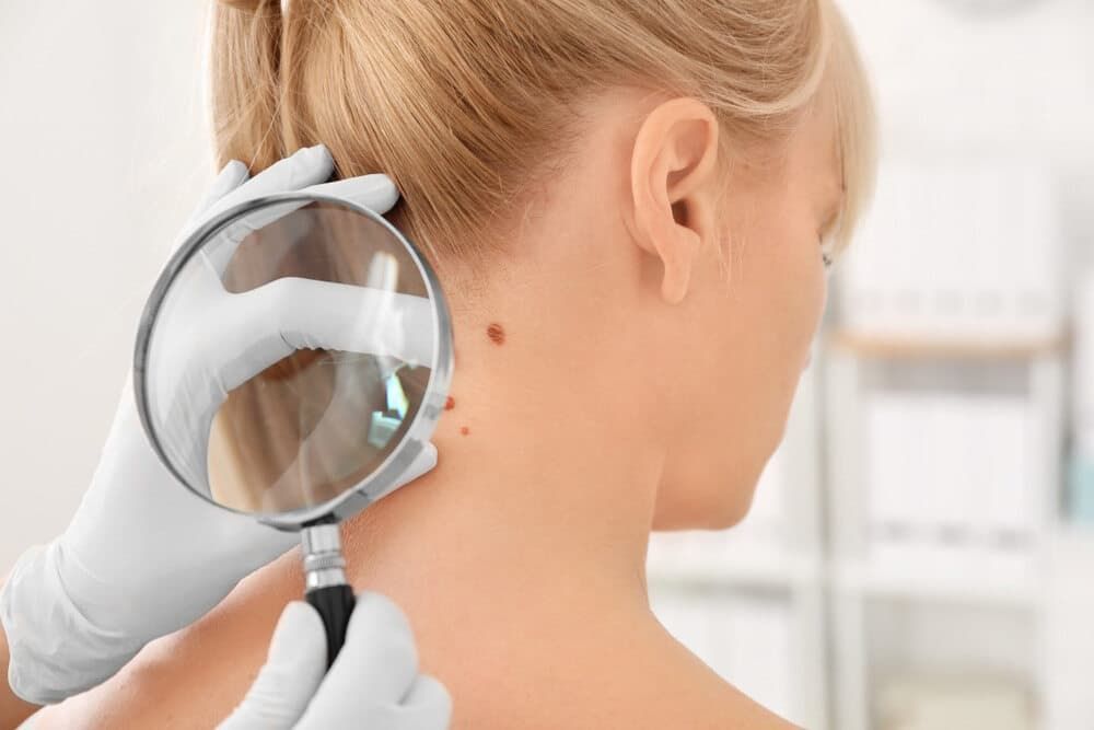 A Doctor Is Examining A Woman's Neck With A Magnifying Glass — Health Hub Mackay In Sarina, QLD