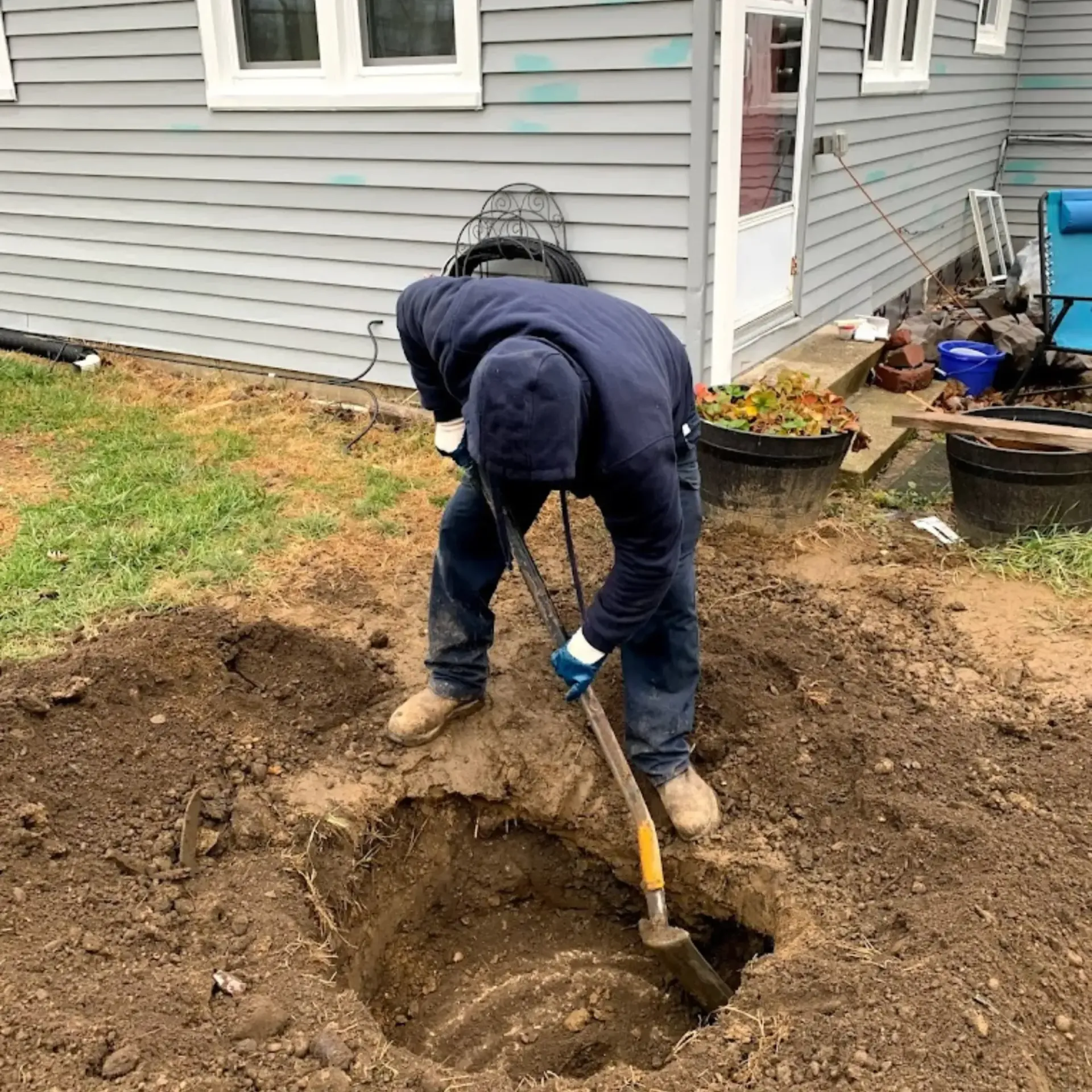 Affordable Waste Services - A man is digging a hole in the dirt with a shovel.