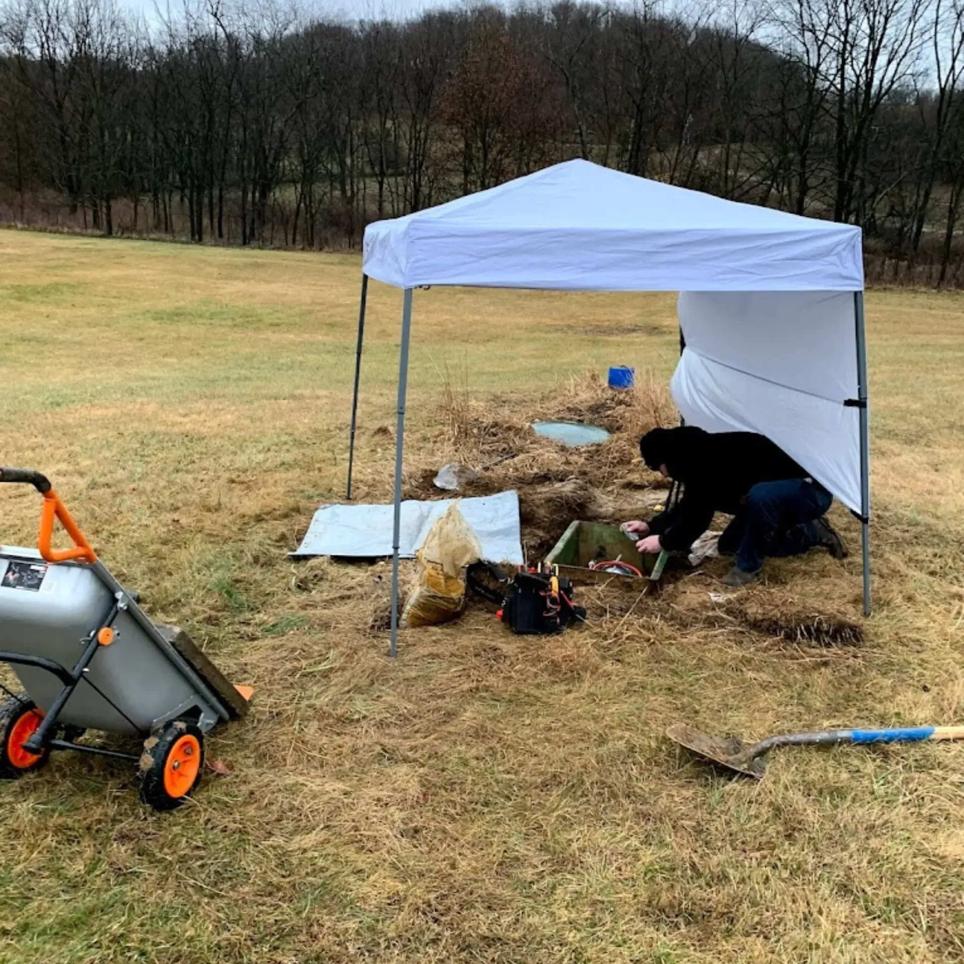 Affordable Waste Services - A man is kneeling under a white tent in a field.