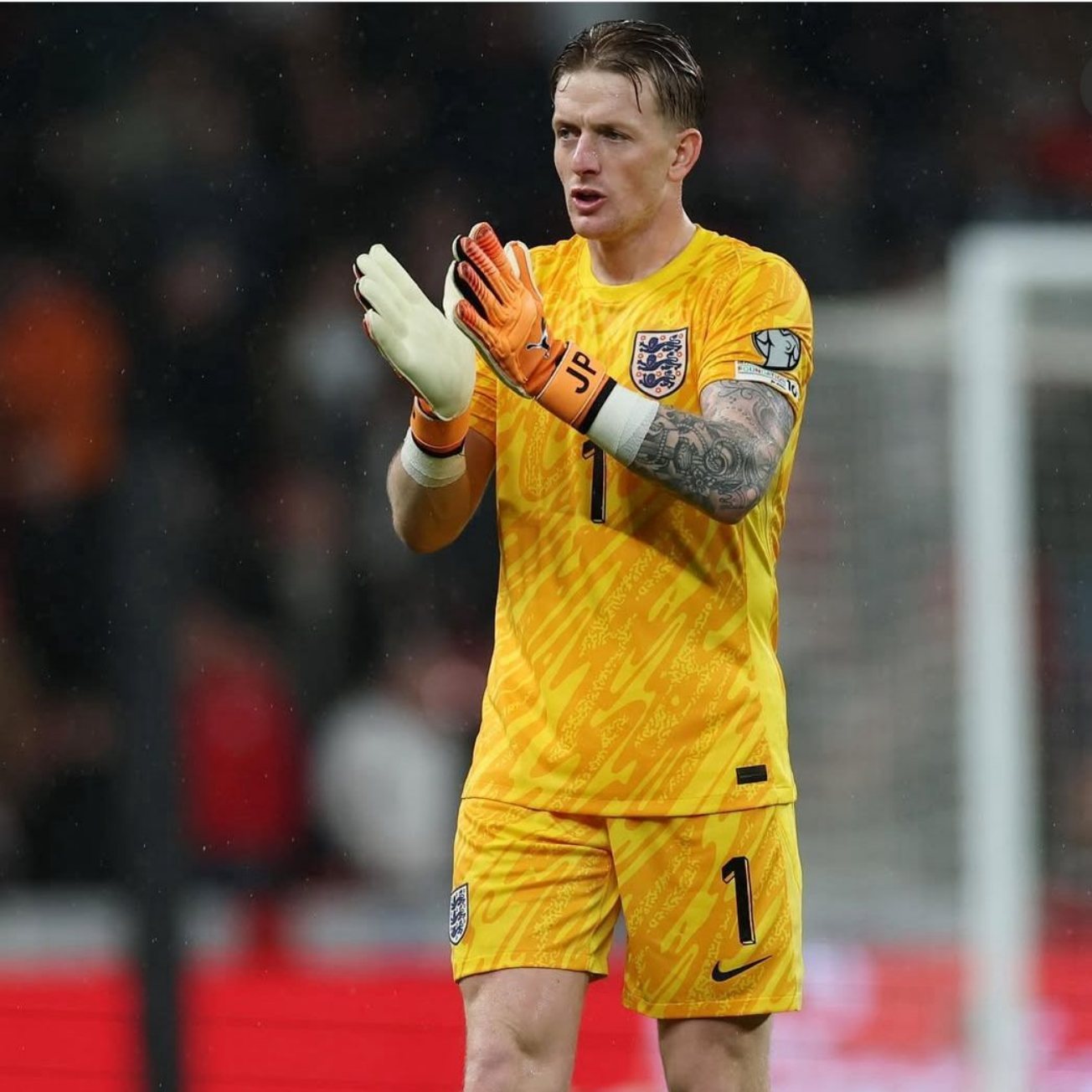 England goalkeeper in yellow kit applauding.