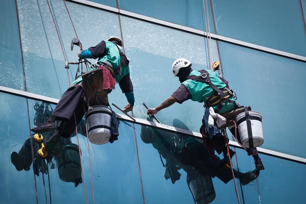Two Men Are Cleaning the Windows of A Tall Building — KJ's Elite Cleaning Services Newcastle in East Maitland, NSW