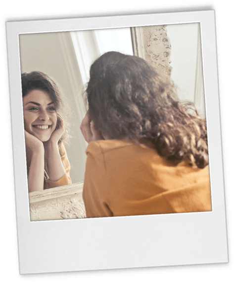 Headshot tip 8 polaroid of a woman smiling in front of a mirror