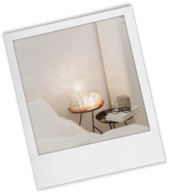 Headshot tip 9 polaroid of a white bed with a cup of water on a bedside table and glass lamps