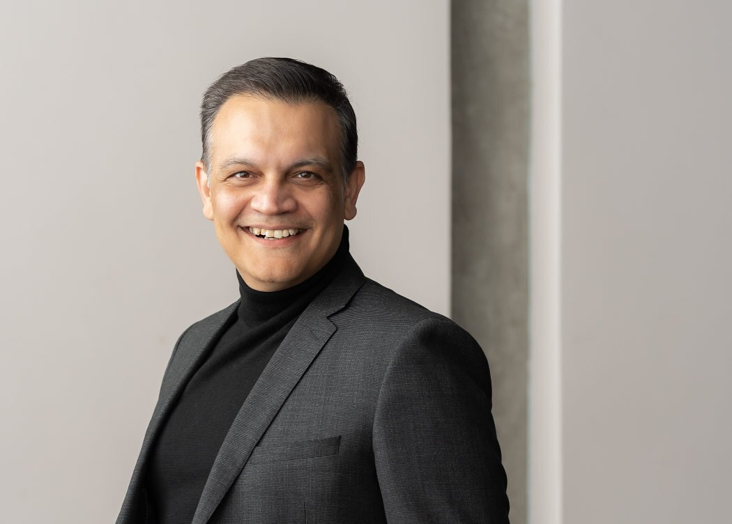 A professional portrait of a man wearing a black turtleneck