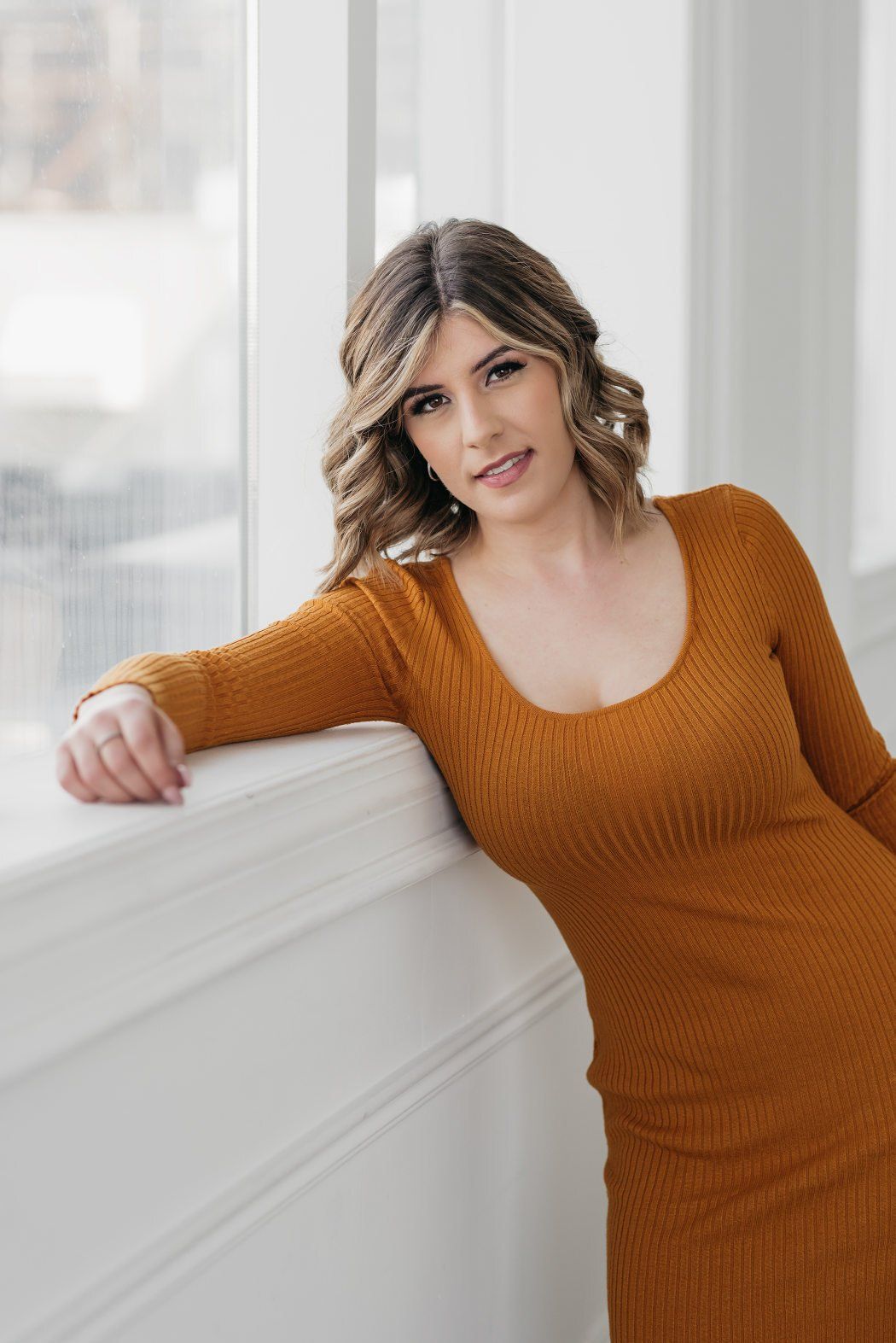 a woman wearing orange dress leaning towards the table