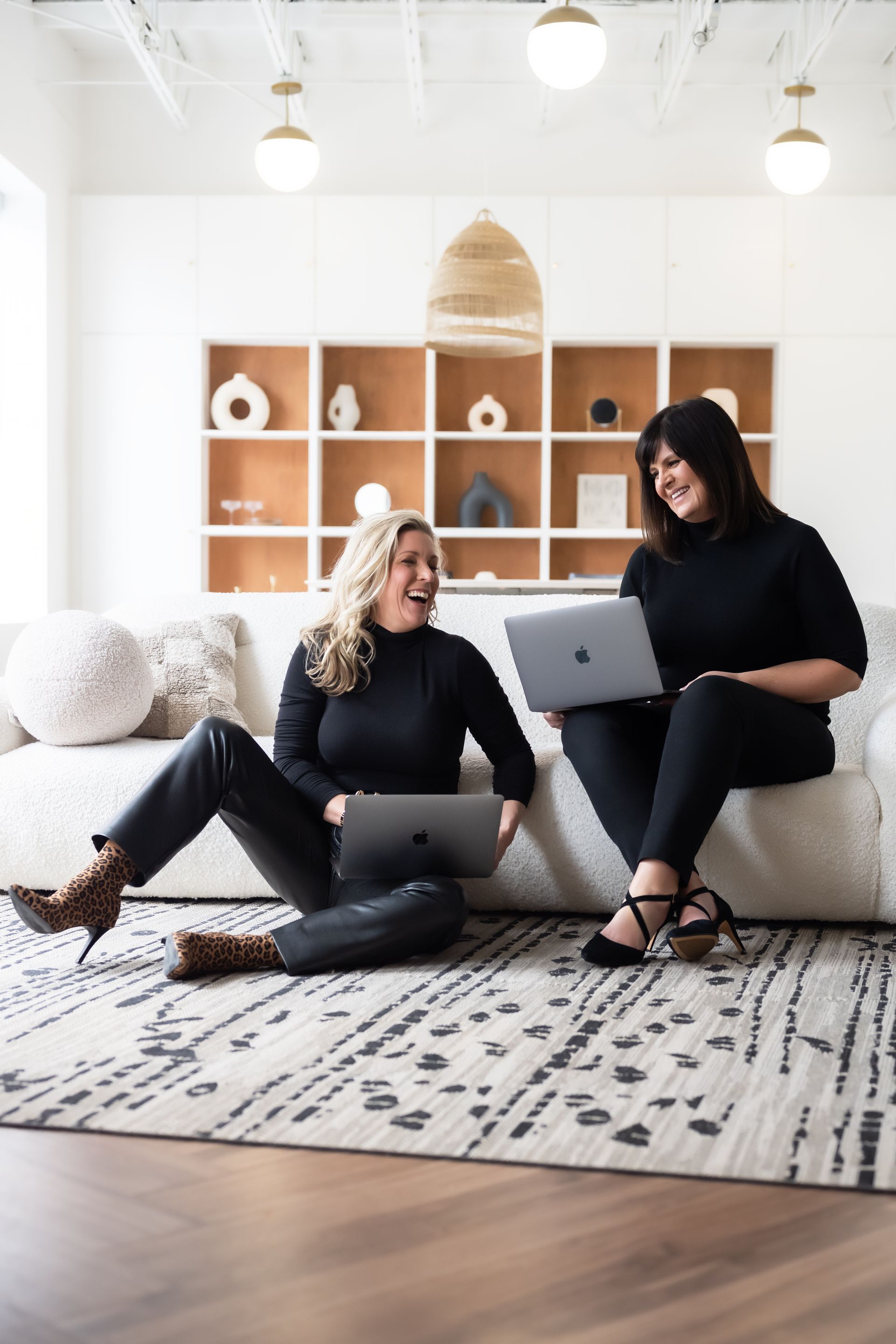 two realtors using their laptop while talking to each other