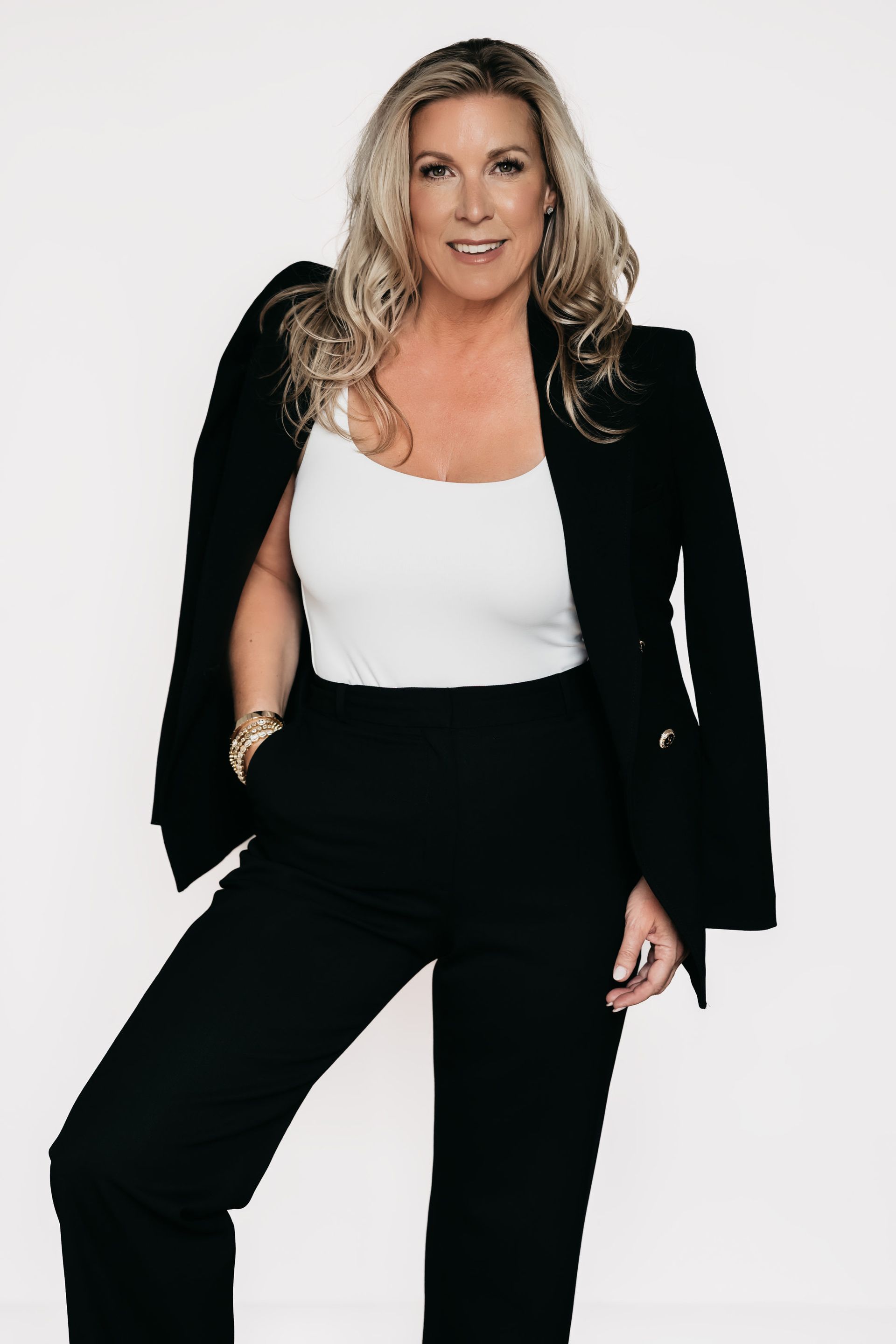 a woman in a black blazer and wide leg pants