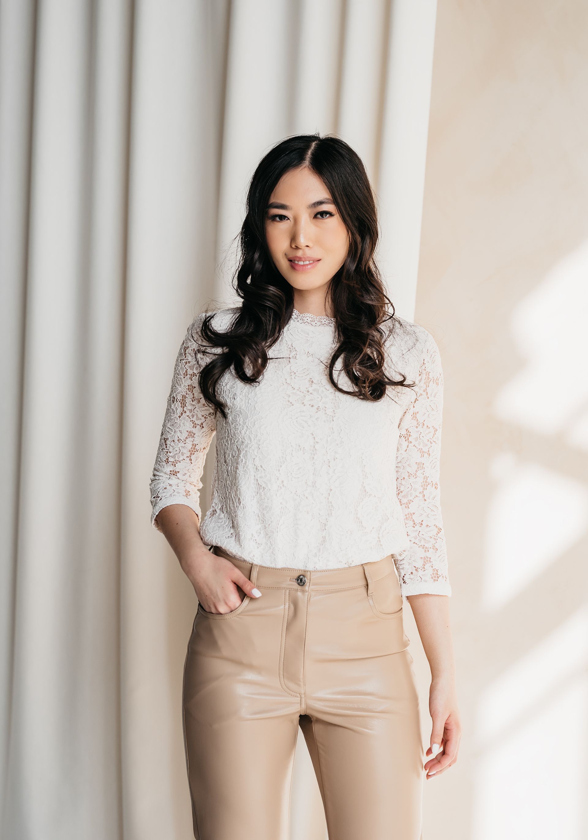 woman wearing white tops and khaki bottoms looking at the camera