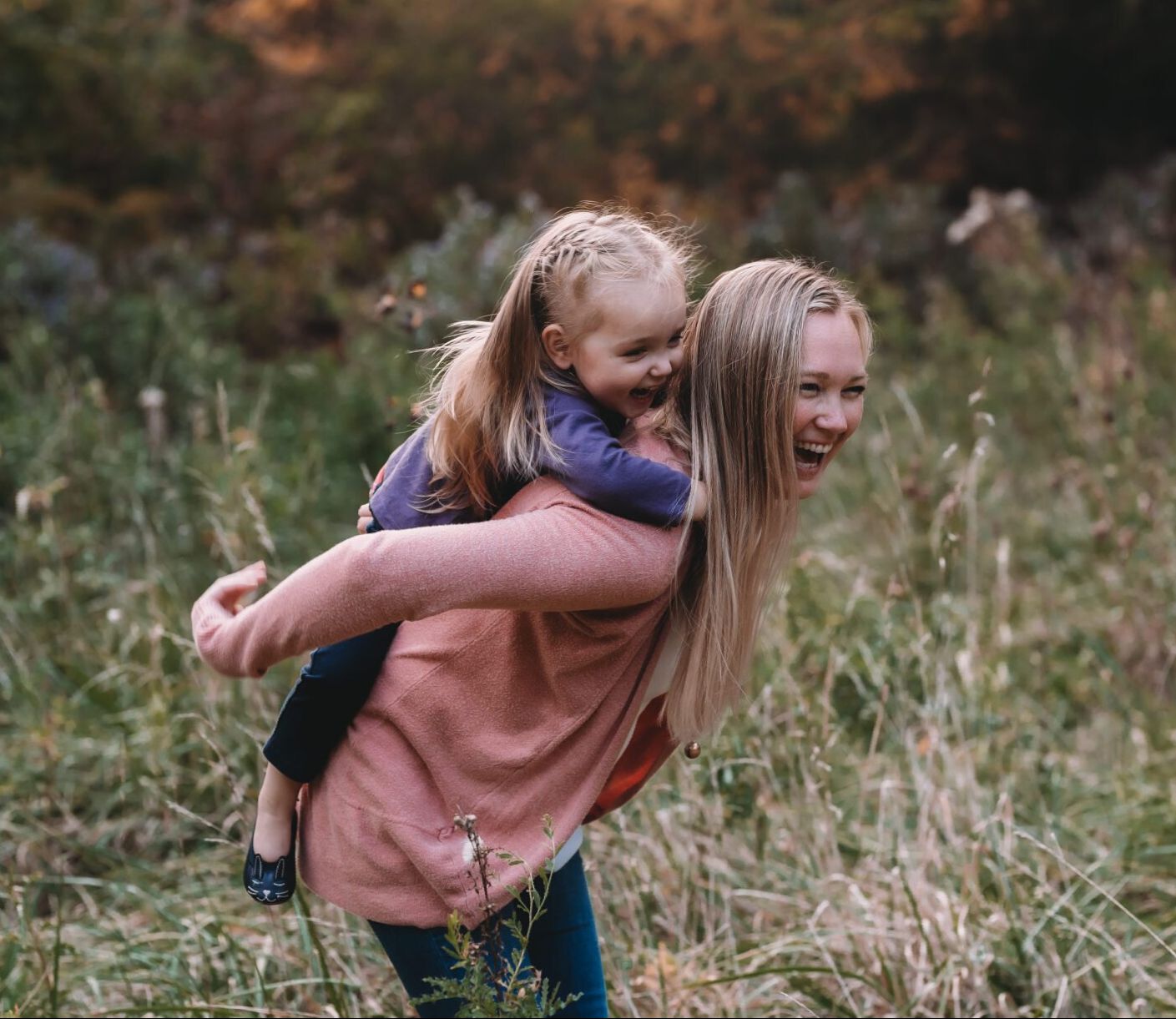 Photo of a girl giving her younger sister a piggy back ride for fun family photography
