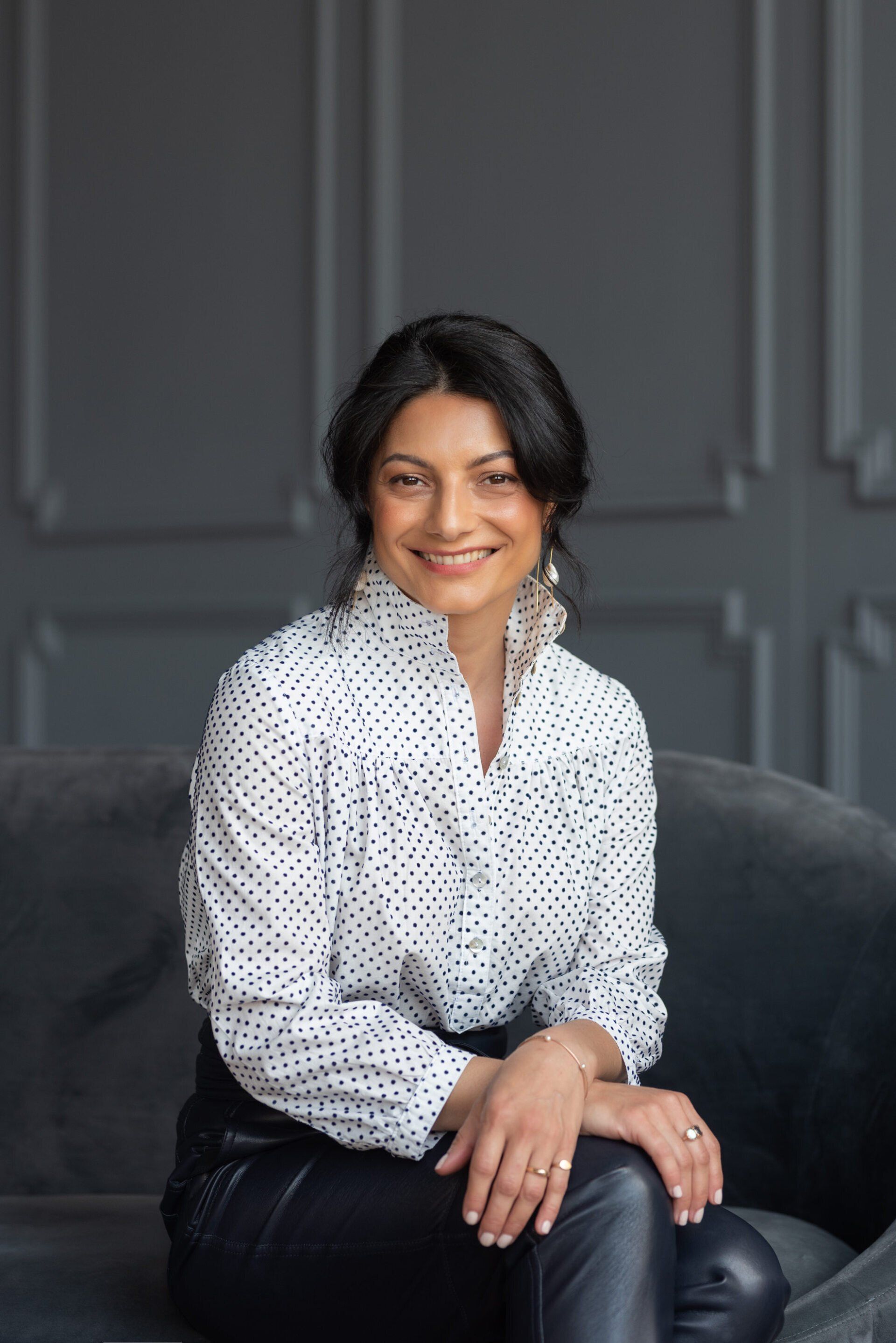 A female executive sitting with hands relaxed and resting on her crossed legs