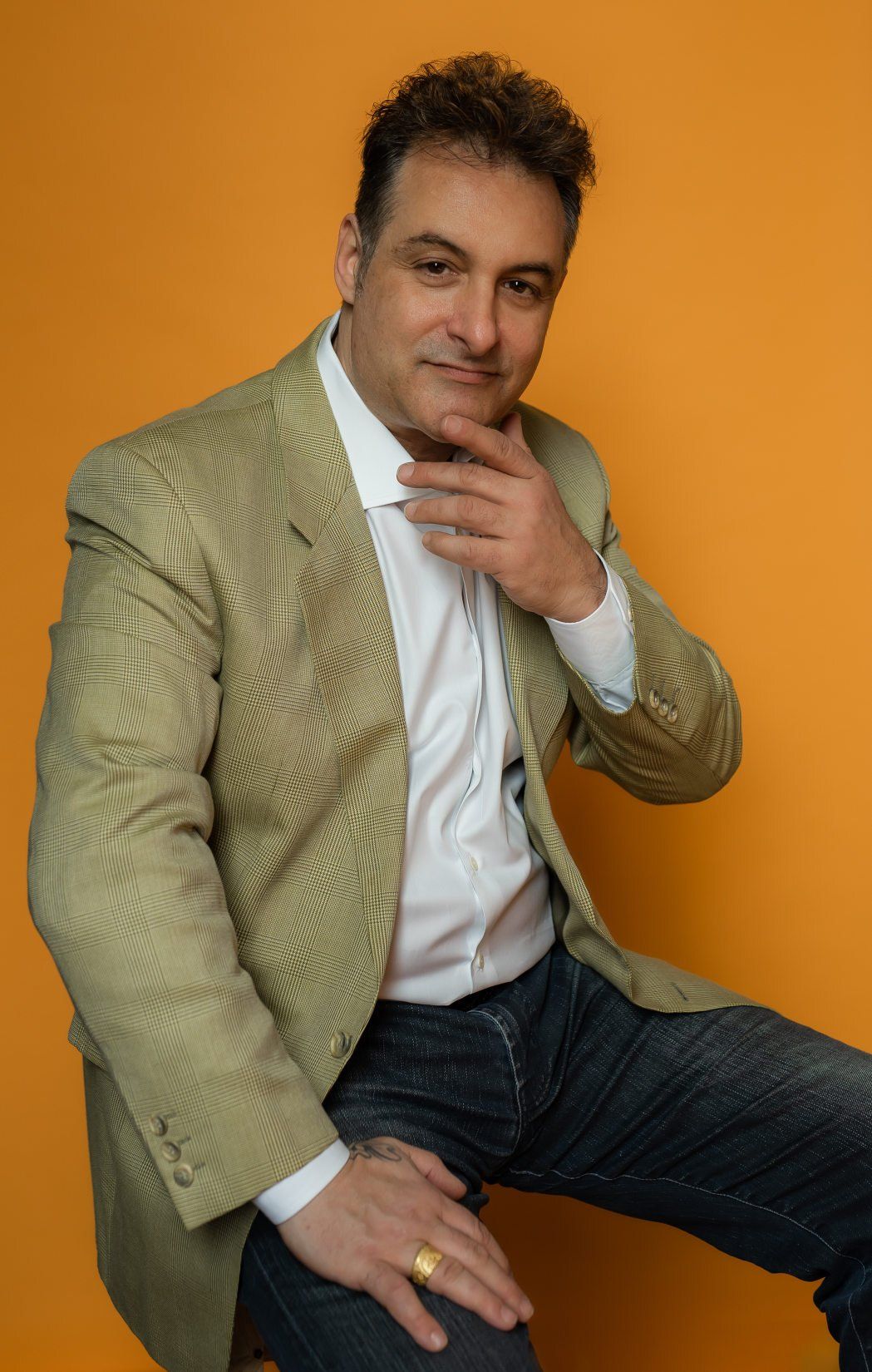 Toronto Greektown business owner wearing green suit posing for the camera