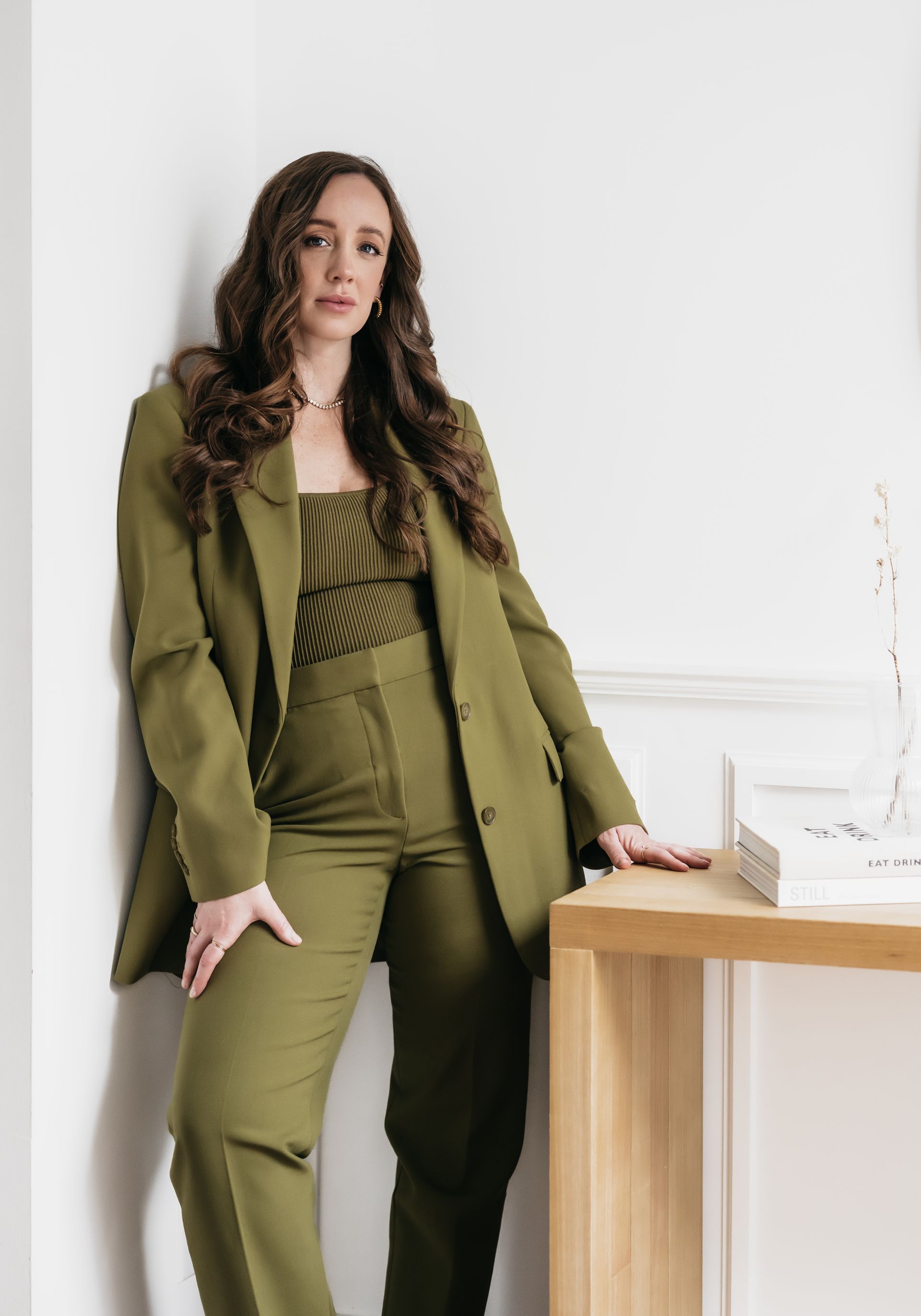 long-haired woman wearing forest green formal attire posing for the camera