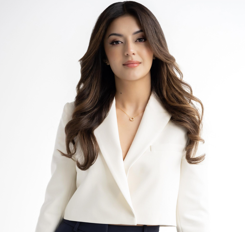 A woman is wearing a white jacket and black pants