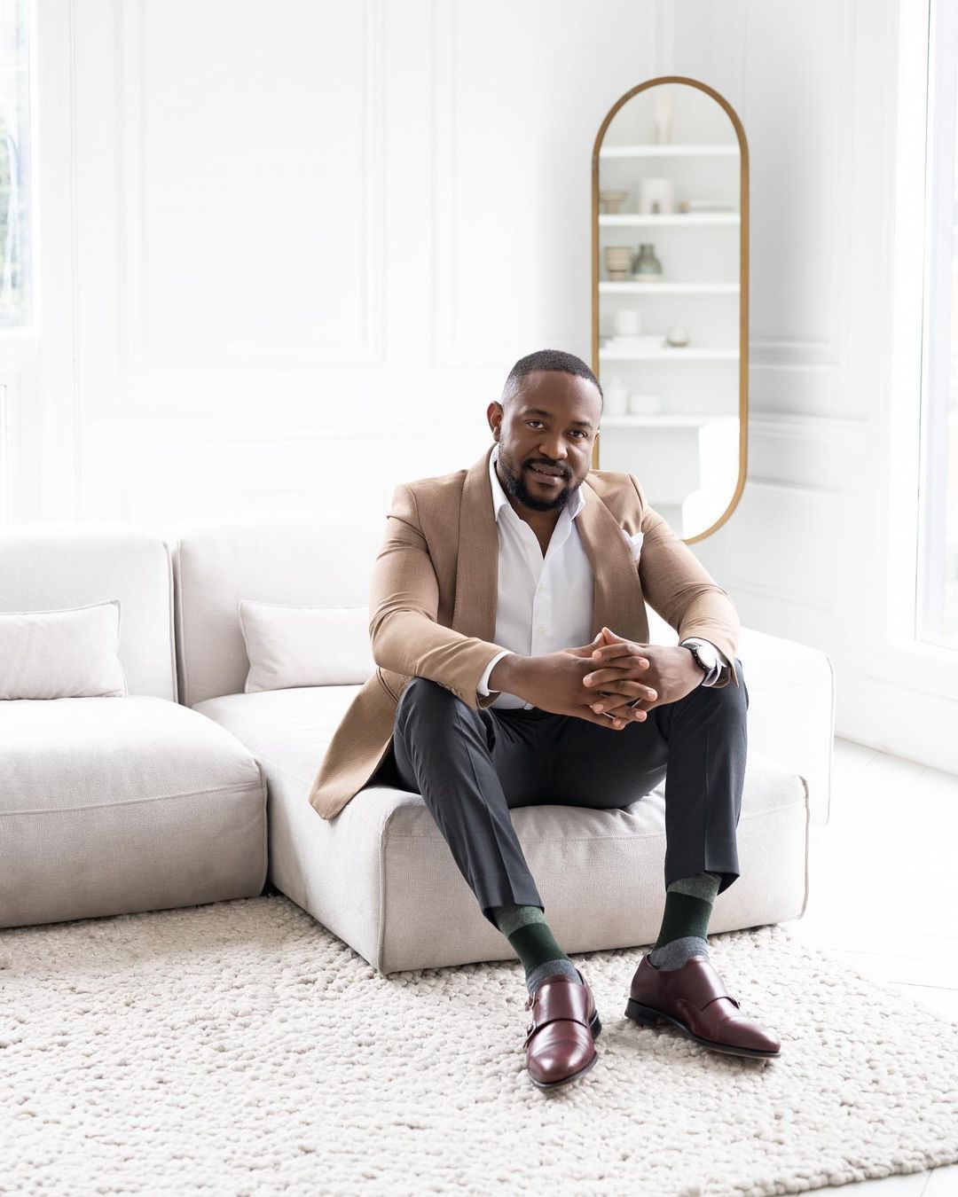 man wearing brown and white suit sitting on a white couch