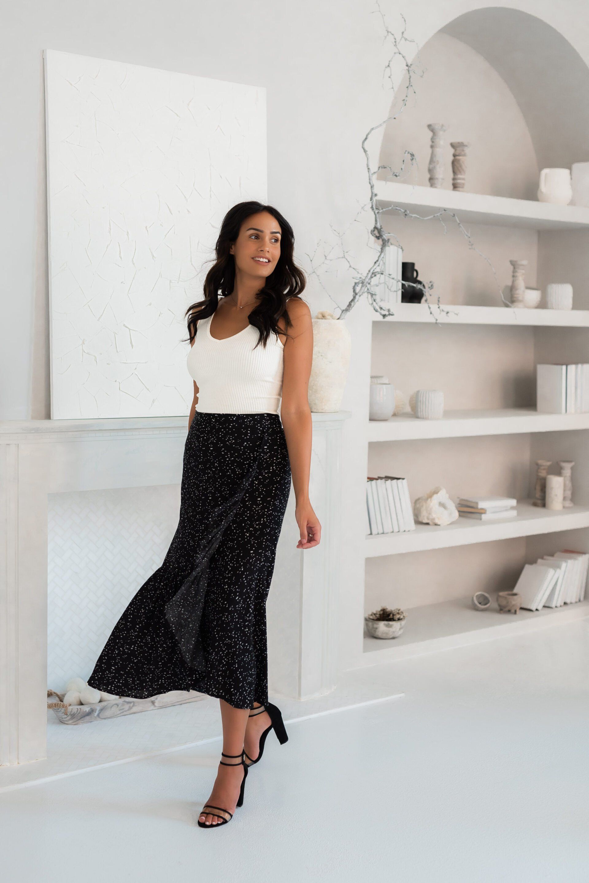 Social influencer Chantel in a white top, black skirt and black heels