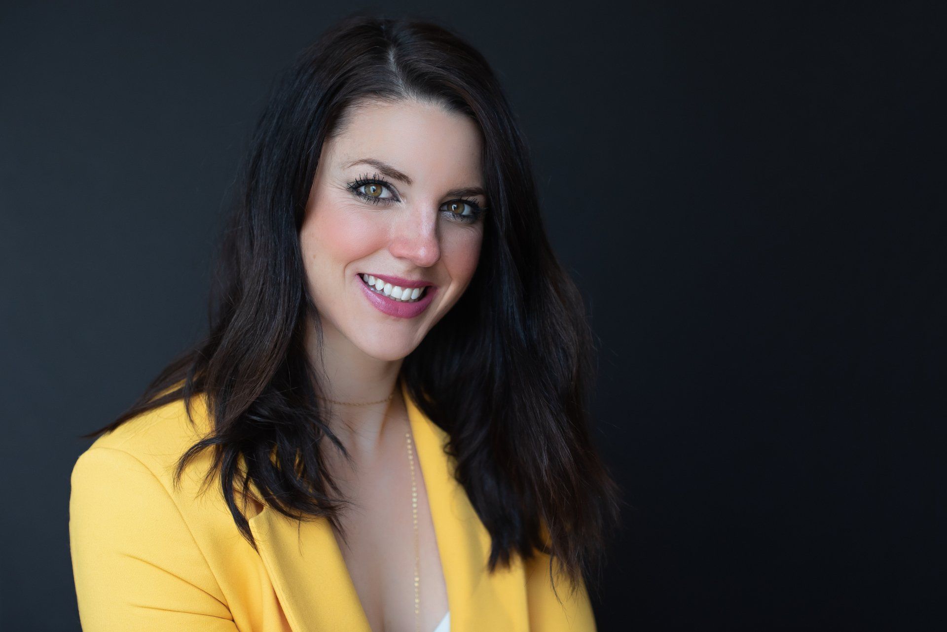 A young professional wearing a yellow blazer